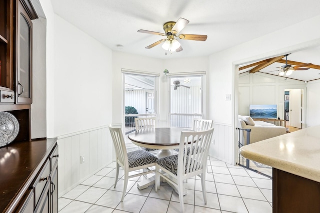 tiled dining area featuring ceiling fan and lofted ceiling with beams