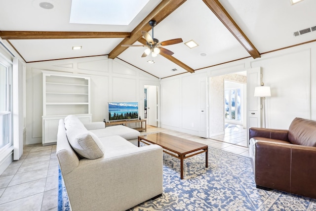 living room featuring ceiling fan, plenty of natural light, built in features, and lofted ceiling with beams