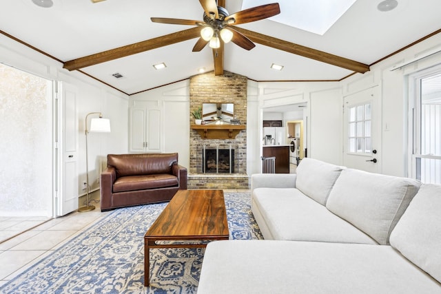 tiled living room featuring ceiling fan, lofted ceiling with beams, and a fireplace