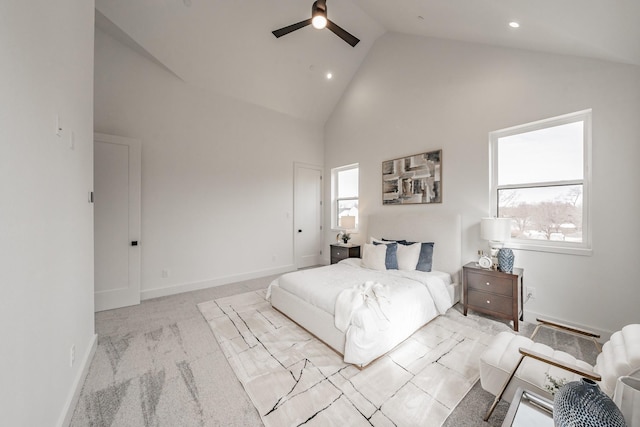 bedroom with ceiling fan, high vaulted ceiling, and light carpet