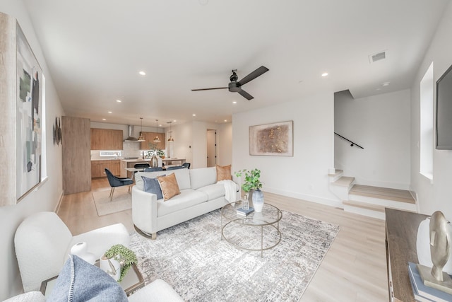 living room featuring ceiling fan and light hardwood / wood-style floors