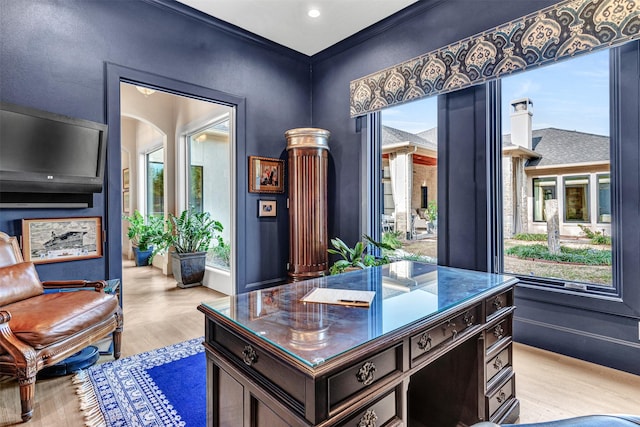 home office with light hardwood / wood-style flooring and ornamental molding