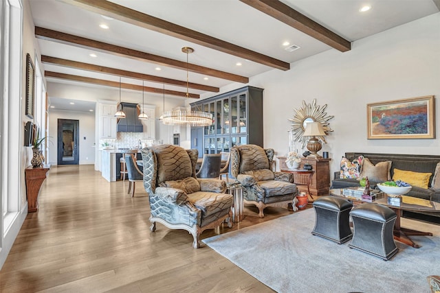 living room with light hardwood / wood-style flooring and beamed ceiling