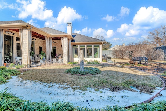 rear view of property with ceiling fan and a patio