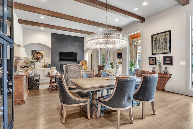 dining area featuring an inviting chandelier, light hardwood / wood-style flooring, and beamed ceiling