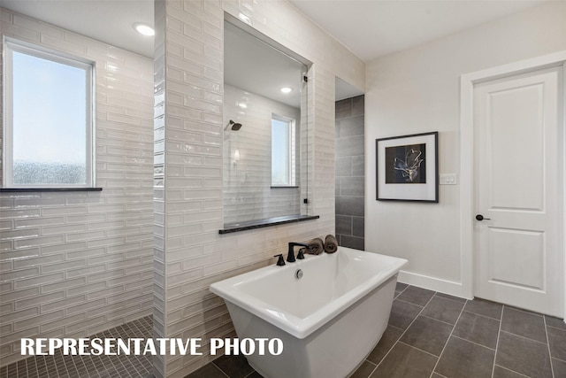 bathroom with plus walk in shower, tile patterned floors, and tile walls