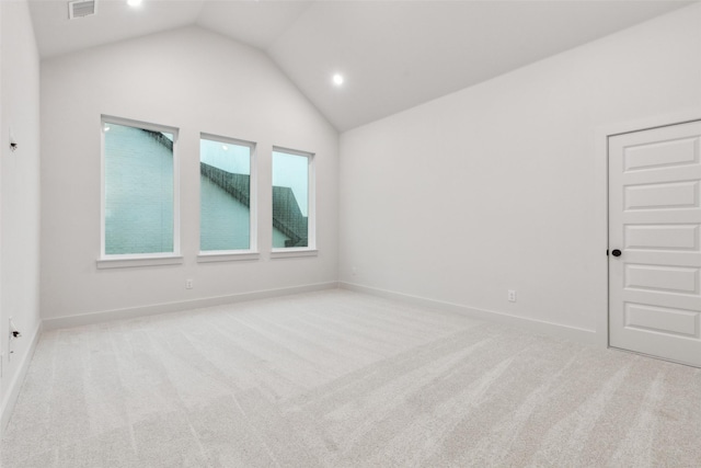 empty room featuring visible vents, carpet flooring, baseboards, and vaulted ceiling