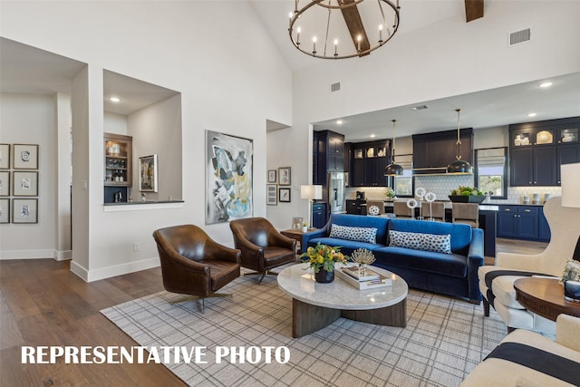 living room featuring high vaulted ceiling, light hardwood / wood-style floors, and a notable chandelier