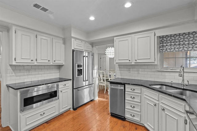 kitchen featuring light hardwood / wood-style floors, sink, white cabinetry, and appliances with stainless steel finishes