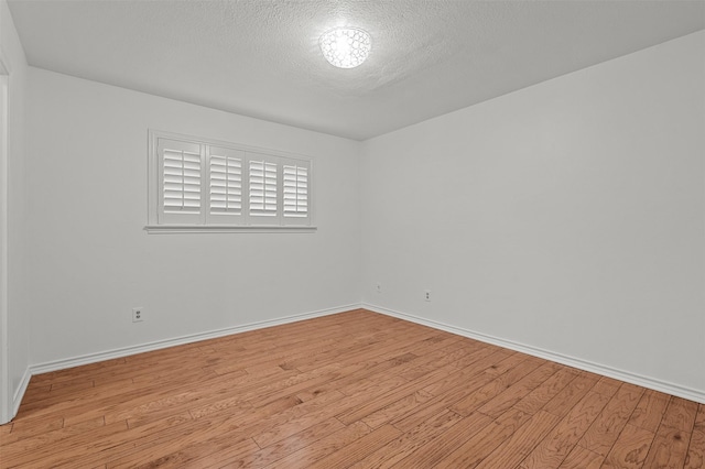 unfurnished room featuring light hardwood / wood-style floors and a textured ceiling