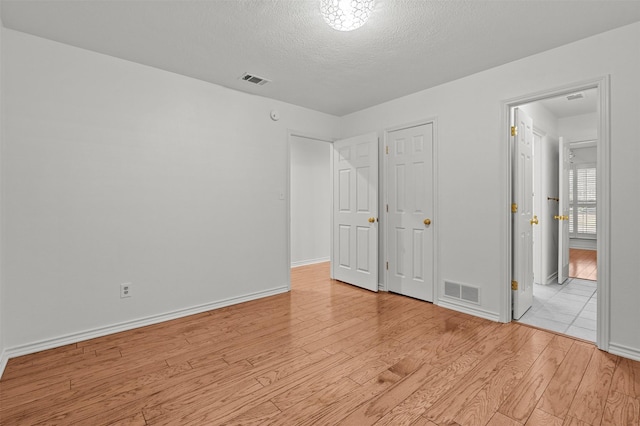 unfurnished bedroom featuring a textured ceiling and light wood-type flooring