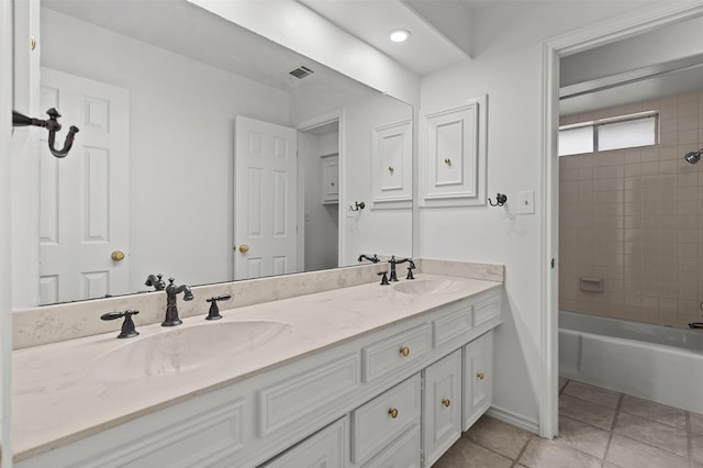 bathroom featuring tiled shower / bath, tile patterned floors, and vanity