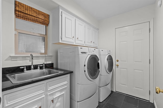 washroom with sink, separate washer and dryer, cabinets, and dark tile patterned floors