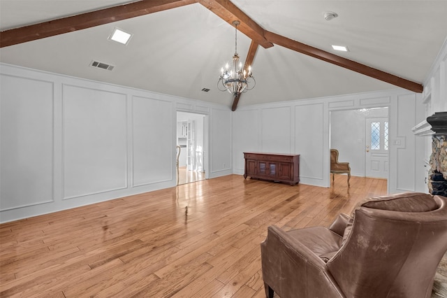 living room with light hardwood / wood-style floors, an inviting chandelier, and vaulted ceiling with beams