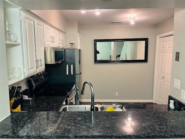 kitchen featuring sink, white cabinetry, range with electric cooktop, and dark stone countertops