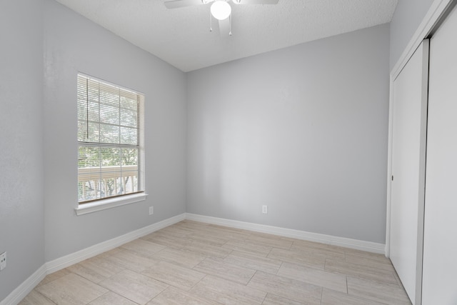 interior space featuring ceiling fan, a textured ceiling, and a closet