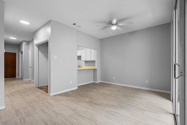 unfurnished living room featuring a textured ceiling and ceiling fan