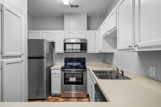 kitchen featuring sink, white cabinetry, stainless steel appliances, and a textured ceiling