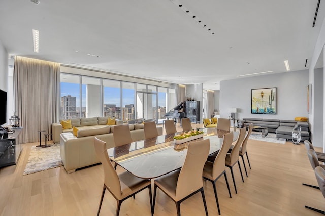 dining area with expansive windows and light hardwood / wood-style flooring