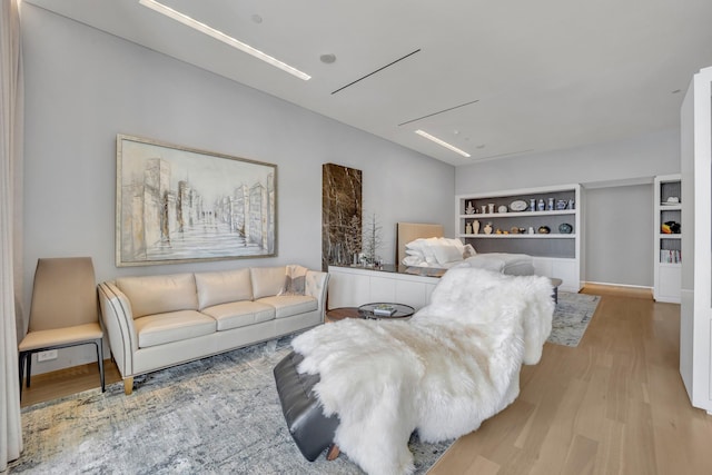 living room with built in features and light wood-type flooring