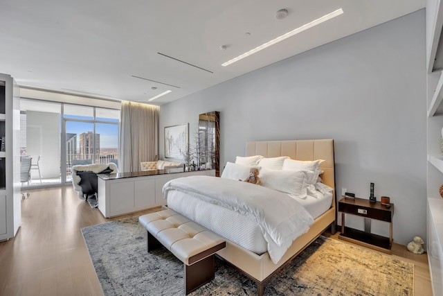 bedroom featuring light hardwood / wood-style floors and expansive windows