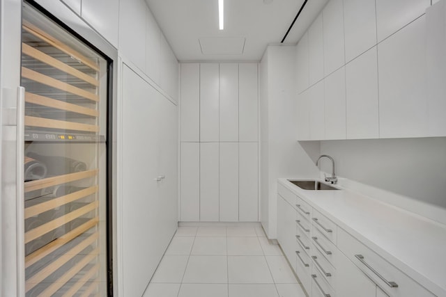 interior space with sink, light tile patterned floors, and beverage cooler