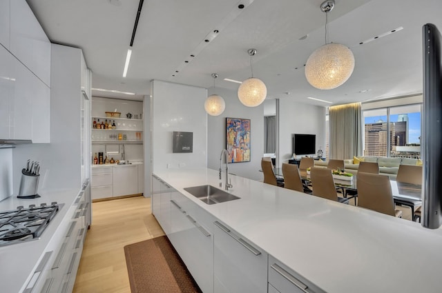 kitchen featuring sink, white cabinets, and pendant lighting