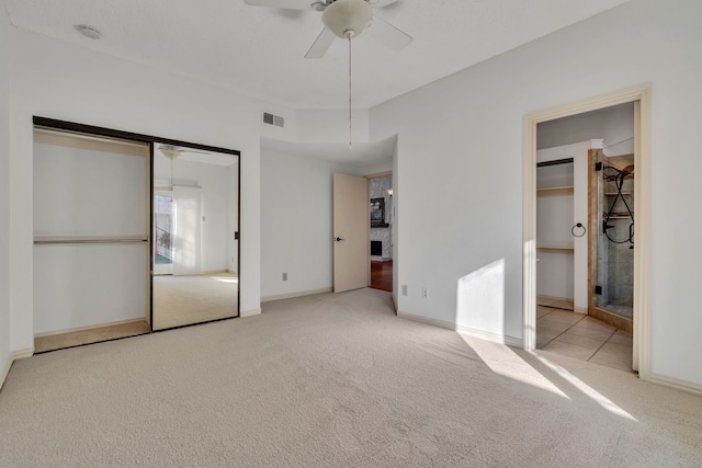 unfurnished bedroom with a closet, ceiling fan, and light carpet