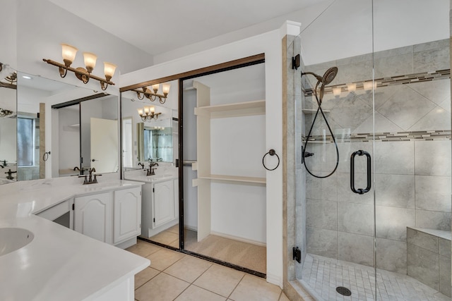 bathroom featuring tile patterned floors, a shower with door, and vanity