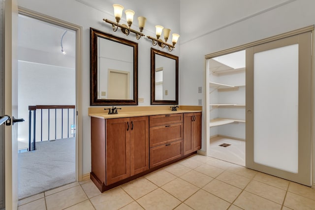 bathroom featuring an inviting chandelier, tile patterned flooring, and vanity