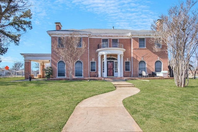 view of front of house featuring a balcony and a front yard