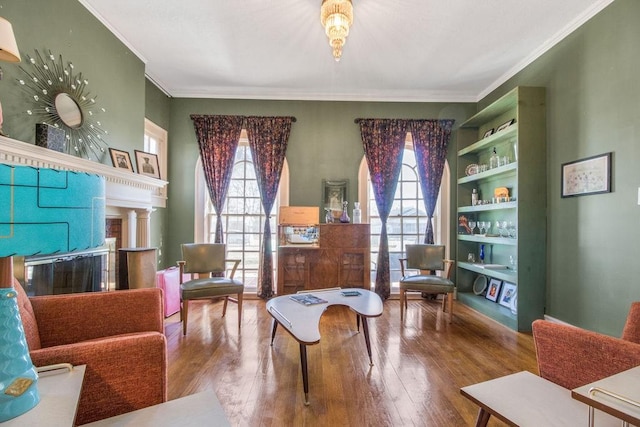 living area with wood-type flooring and ornamental molding