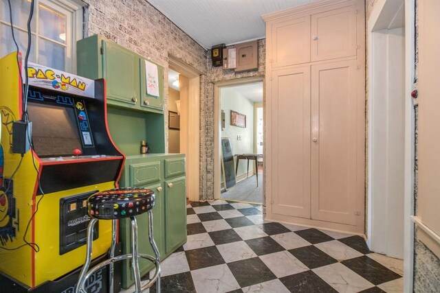 kitchen featuring brick wall and green cabinetry