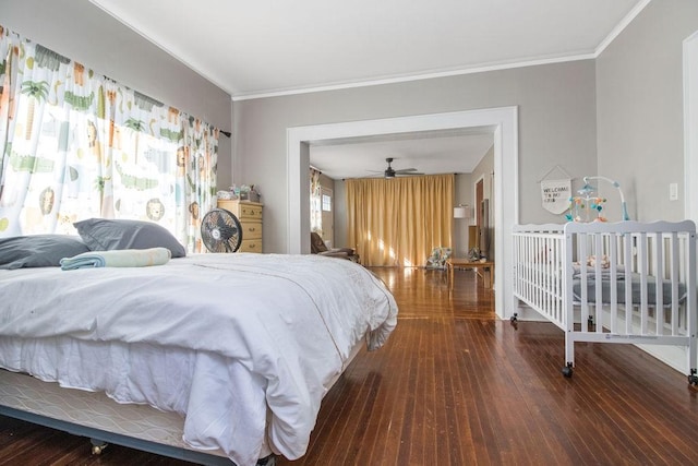 bedroom featuring wood-type flooring, multiple windows, and crown molding