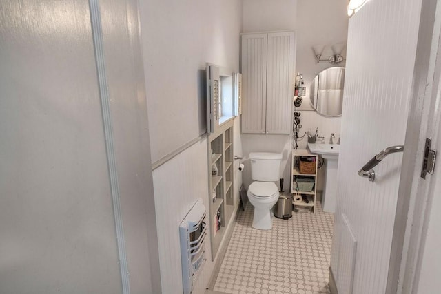 bathroom featuring toilet and heating unit