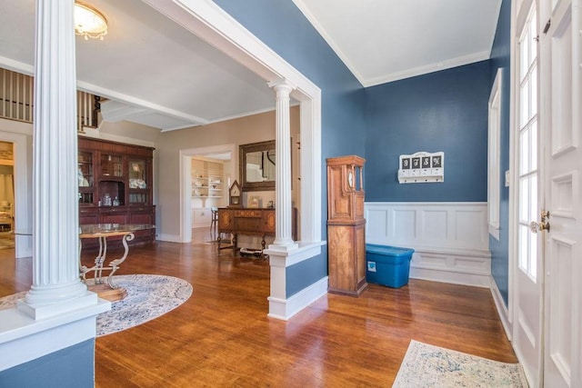 foyer featuring hardwood / wood-style flooring, ornamental molding, ornate columns, and beamed ceiling