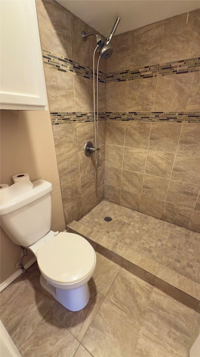 bathroom with toilet and tiled shower