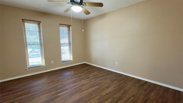 empty room featuring a textured ceiling, dark hardwood / wood-style floors, and ceiling fan