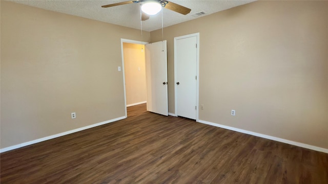 unfurnished bedroom featuring ceiling fan, dark wood-type flooring, and a textured ceiling