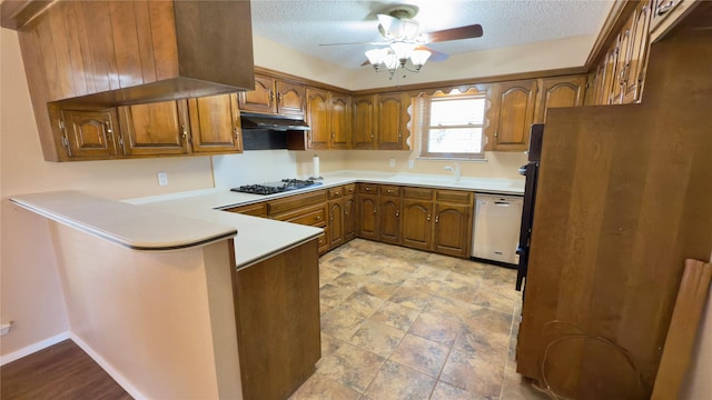 kitchen with kitchen peninsula, stainless steel dishwasher, black gas stovetop, a textured ceiling, and refrigerator