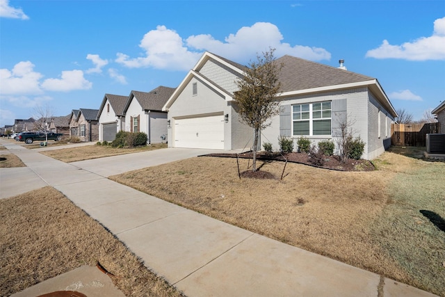 view of front facade featuring a garage, cooling unit, and a front lawn