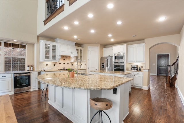 kitchen with a spacious island, white cabinetry, appliances with stainless steel finishes, and sink