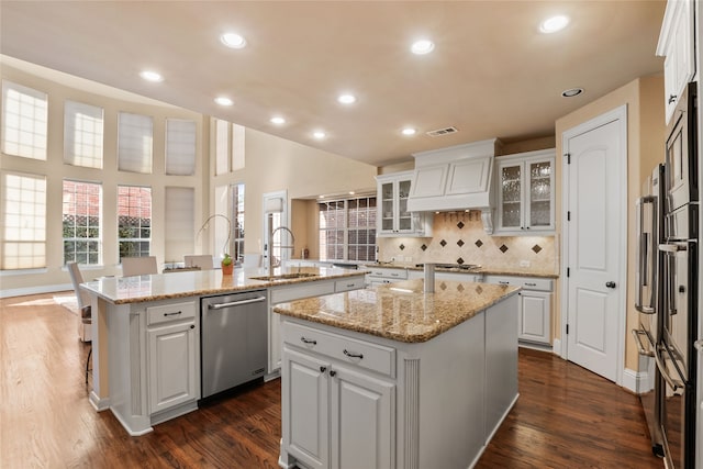 kitchen featuring sink, white cabinetry, and a kitchen island with sink