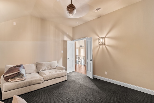 living room with ceiling fan, carpet flooring, and lofted ceiling