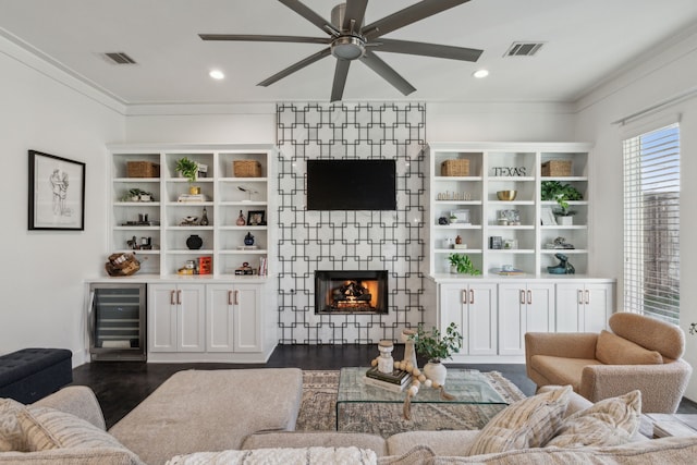 living room with dark hardwood / wood-style flooring, beverage cooler, a large fireplace, and ceiling fan