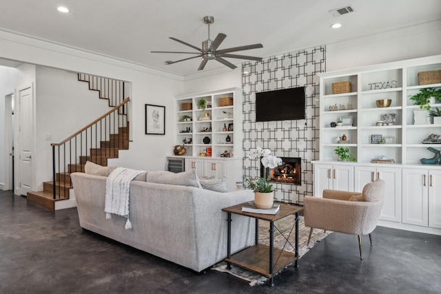 living room featuring crown molding, ceiling fan, and a fireplace