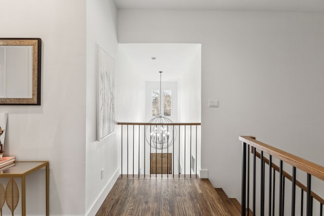 hallway with dark hardwood / wood-style flooring and a notable chandelier