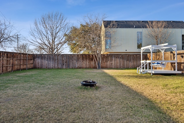 view of yard featuring a deck and a fire pit