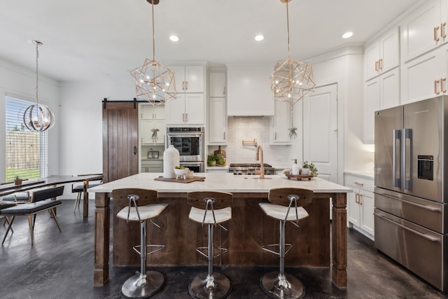 kitchen with pendant lighting, stainless steel appliances, and a barn door