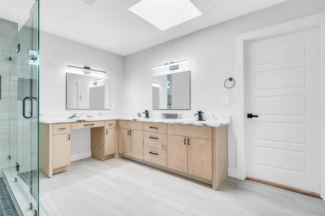 bathroom with walk in shower, a skylight, and vanity